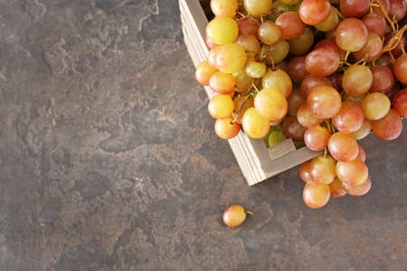 Tasty fresh grapes in box on grunge backgroundの写真素材