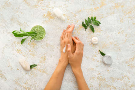 Female hands with natural cream on light backgroundの写真素材