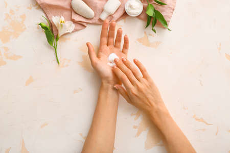 Female hands with natural cream on light backgroundの写真素材