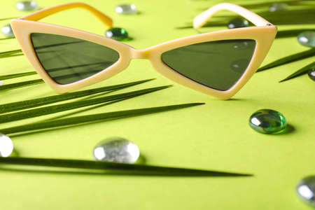 Stylish sunglasses on color background