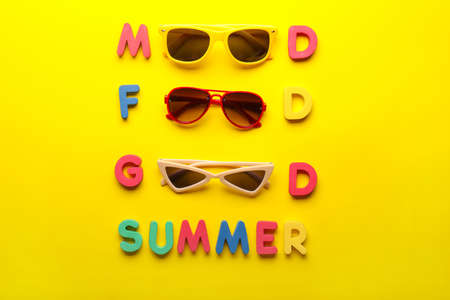 Composition with stylish sunglasses and letters on color backgroundの写真素材