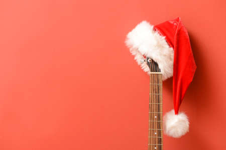 Guitar with Santa Claus hat on color backgroundの写真素材