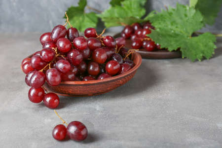 Tasty sweet grapes on gray table