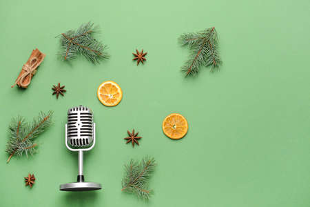 Retro microphone with Christmas decor on color background
