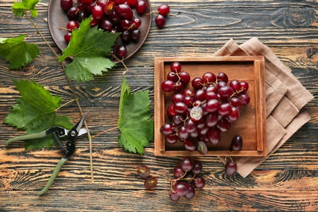 Tasty sweet grapes on wooden table