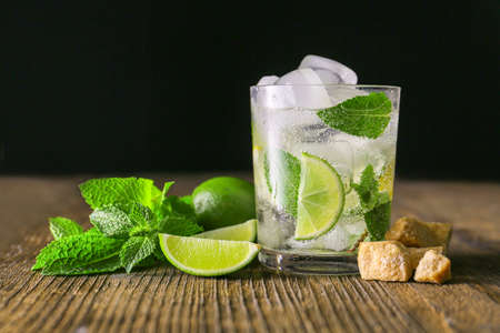 Glass of fresh mojito on wooden table against dark backgroundの写真素材