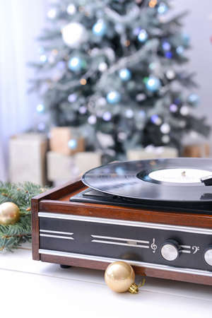 Record player on table in room decorated for Christmas