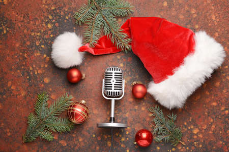 Retro microphone with Christmas decor and Santa Claus hat on color backgroundの写真素材