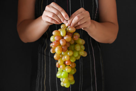 Woman holding tasty sweet grapes, closeupの写真素材