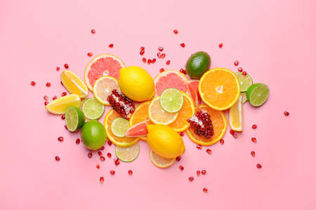Different sliced citrus fruits on color backgroundの写真素材