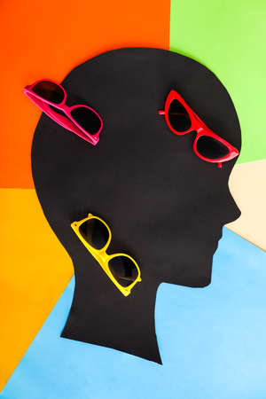 Paper human head with stylish sunglasses on color background
