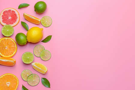 Different sliced citrus fruits on color backgroundの写真素材