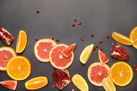 Different sliced citrus fruits on dark backgroundの写真素材