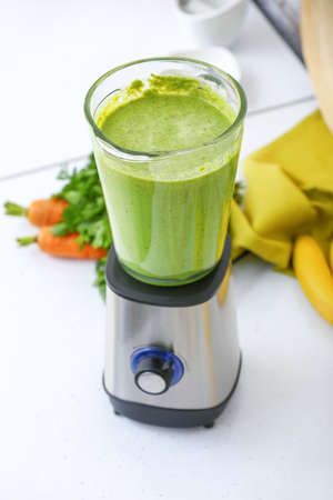 Blender with healthy smoothie on table in kitchen