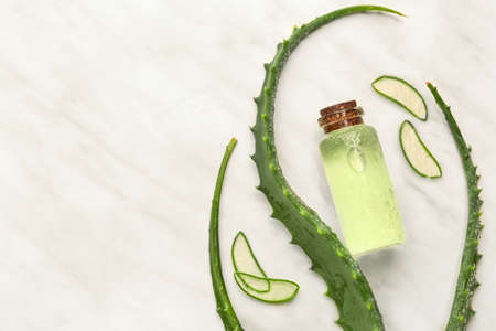 Bottle of essential oil with aloe leaves on light backgroundの写真素材