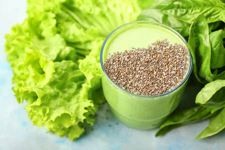 Glass of tasty green smoothie with herbs on tableの写真素材