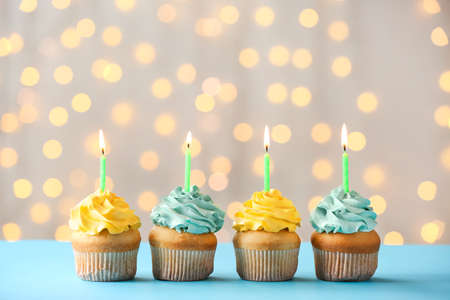 Tasty Birthday cupcakes on table against defocused lightsの写真素材