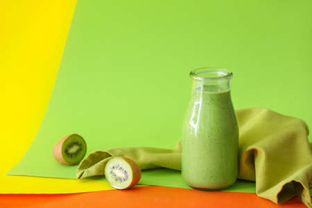 Bottle of tasty green smoothie on color backgroundの写真素材