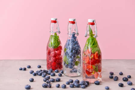 Bottles of fresh infused water on gray table