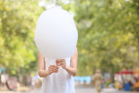 Woman with sweet cotton candy outdoorsの写真素材