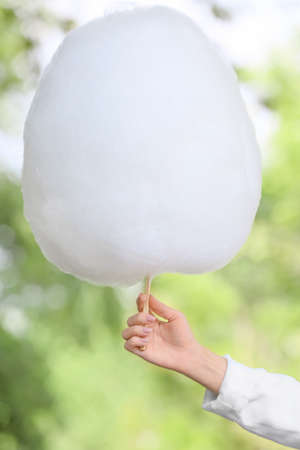 Female hand with sweet cotton candy outdoorsの写真素材