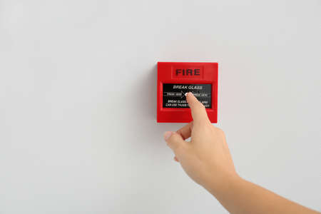 Woman using manual call point of fire alarm systemの写真素材