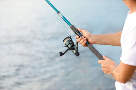 Young man fishing on river, closeupの写真素材