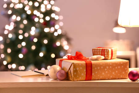 Beautiful Christmas gift boxes and decor on table in room