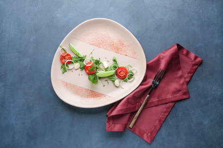 Plate with tasty arugula salad on color backgroundの写真素材