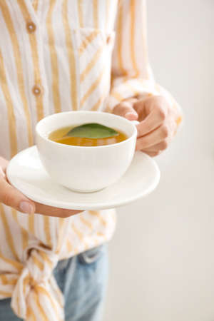 Woman holding cup of hot tea, closeup