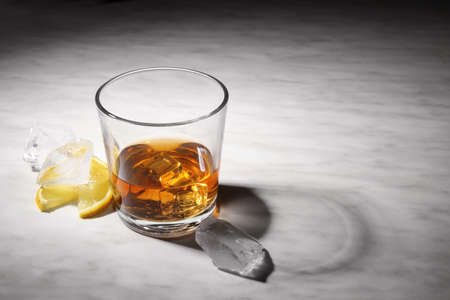 Glass of whiskey on gray table