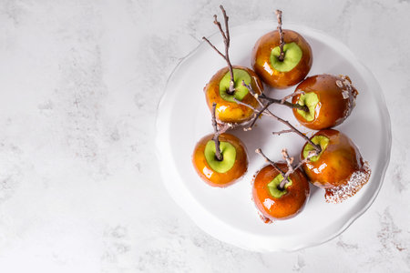 Dessert stand with tasty candy apples on tableの写真素材