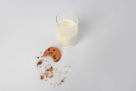 Glass of milk and tasty cookie on white backgroundの写真素材