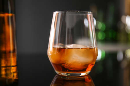 Glass of whiskey on table in bar