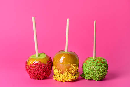 Tasty candy apples on color background