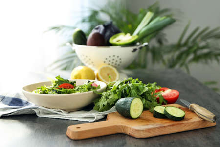 Preparing of tasty salad with arugula on tableの写真素材