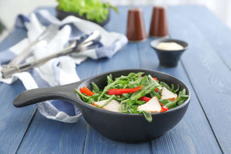 Bowl with tasty arugula salad on wooden tableの写真素材
