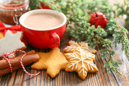 Tasty Christmas cookies and cup of hot chocolate on table
