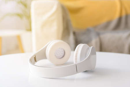 Modern headphones on table in roomの写真素材