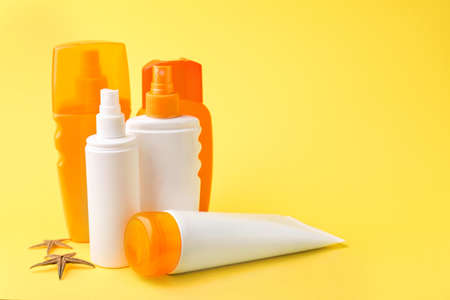 Different sun protection creams on color background