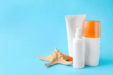 Different sun protection creams and starfish on color backgroundの写真素材