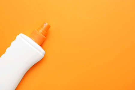 Bottle of sun protection cream on color background