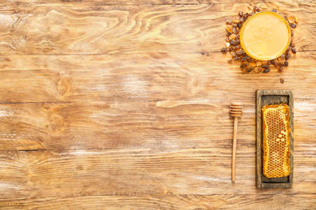 Bowl with sweet honey and combs on wooden backgroundの写真素材