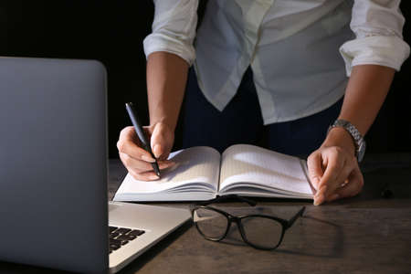 Woman working at table in eveningの写真素材