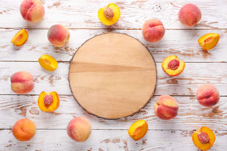 Ripe peaches and board on white wooden backgroundの写真素材