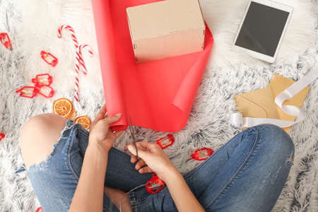 Woman making Christmas gift on floor