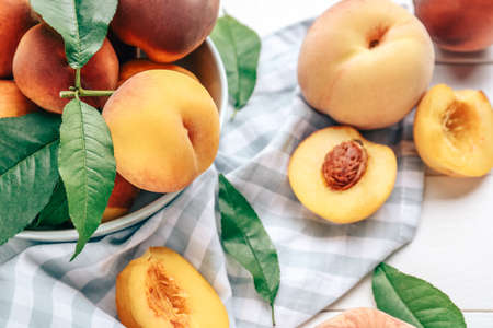 Bowl with tasty peaches on tableの写真素材