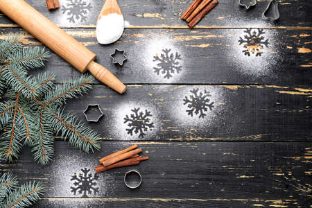 Christmas composition with cookie cutters and flour on dark wooden backgroundの写真素材