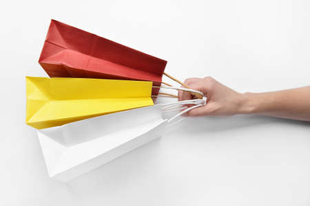 Female hand with shopping bags on white backgroundの写真素材