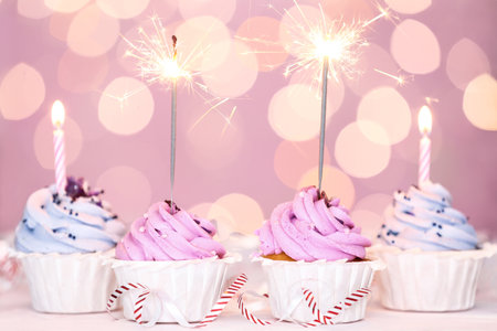 Tasty Birthday cupcakes on table against defocused lightsの写真素材